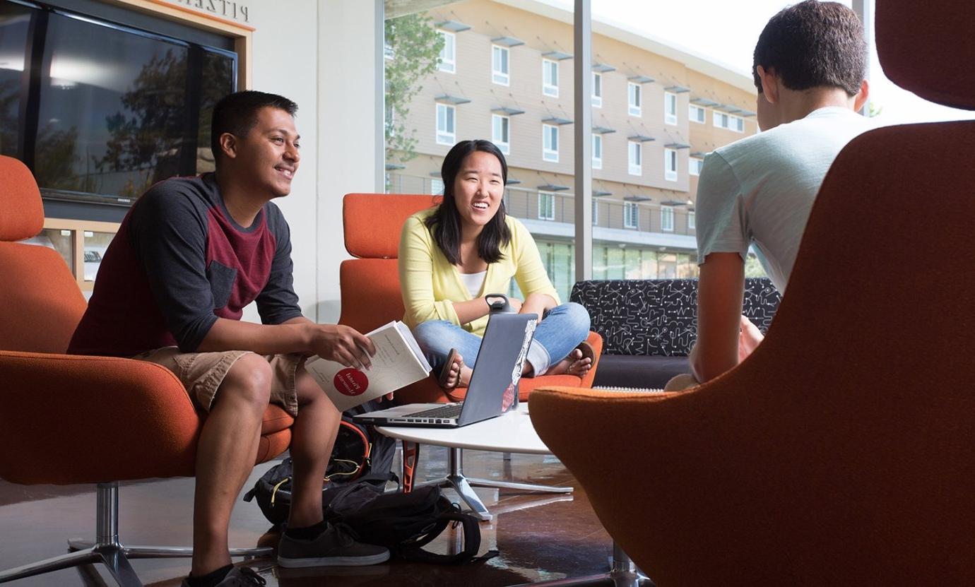 three students sit in the lobby of west hall