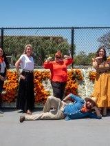 注册商 staff posing in front of Pitzer sign made of flowers